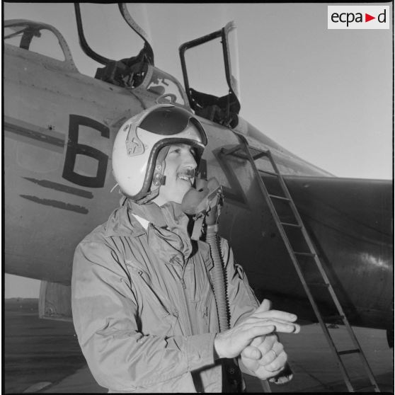 [Pilote de l'armée de l'Air posant devant un avion de chasse.]