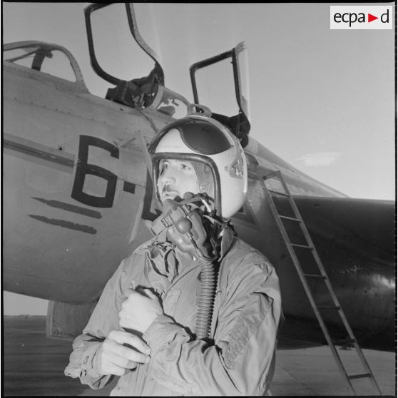 [Pilote de l'armée de l'Air posant devant un avion de chasse.]