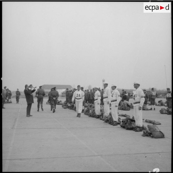 [Caméraman filmant les soldats se préparant pour une épreuve de saut en parachute, en équipe, du Rallye para-neige.]