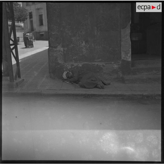 [Homme dormant dans la rue.]