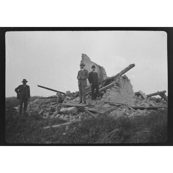 [Trois autorités civiles posant sur un tas de ruines rencontré lors d'une visite à la campagne, s.d.]