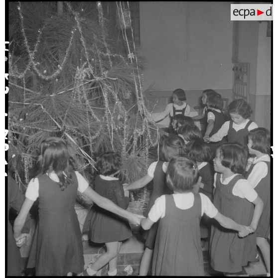 Autour de l'arbre de Noël, la danse traditionnelle des petits enfants lors de la distribution de jouets à l'AFOM.