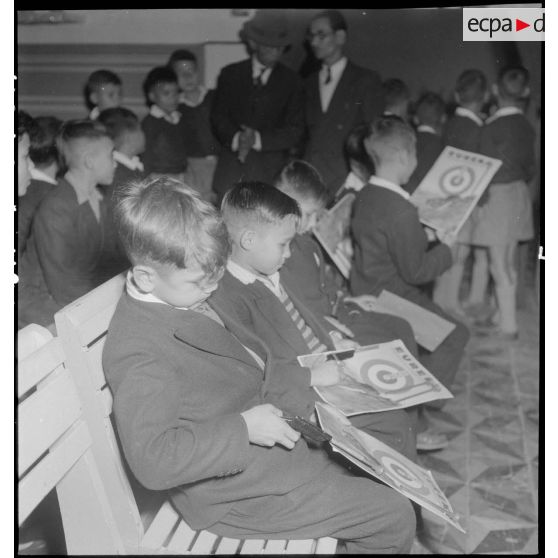 Enfants assis lors de la distribution de jouets à l'AFOM.