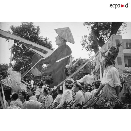 Une banderole sur le char porte des inscriptions tronquées.