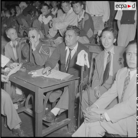 Un homme compte les points du combat de boxe organisé lors de la kermesse au profit des oeuvres de l'asile Saint Antoine.