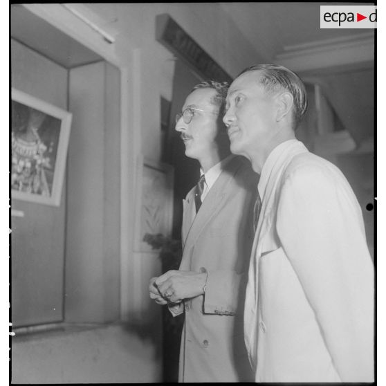 Deux civils contemplant des oeuvres lors du vernissage de l'exposition de peintures de Vincent Dat et de Guy Le Guillerm.