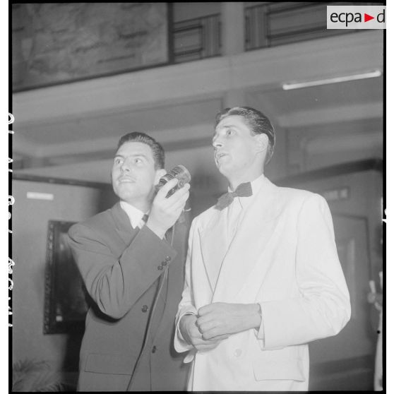 Le Guillerm est interviewé par un journaliste lors du vernissage de l'exposition de peintures Dat -Le Guillerm.