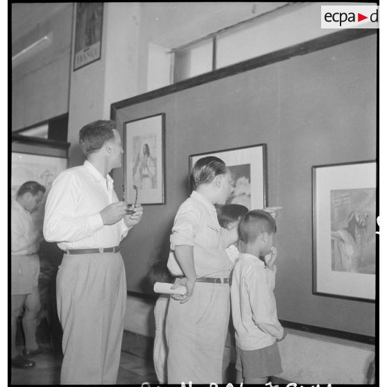 Civils contemplant des tableaux de Vincent Dat au vernissage de l'exposition de peintures Dat -Le Guillerm.