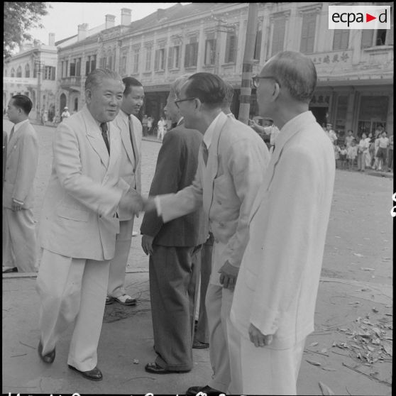 M. Tran Van Huu serre la main d'un civil vietnamien dans une rue d'Hanoï.