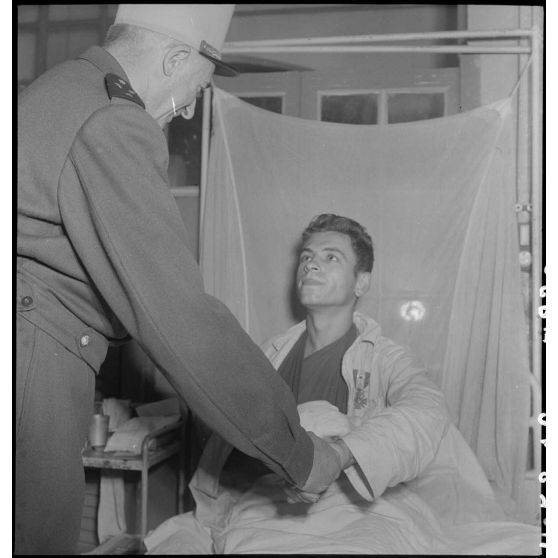 Un légionnaire 2e classe du3/13e DBLE (demi-brigade de Légion étrangère) serre la main du général de Linarès à l'hôpital Lanessan à Hanoï.