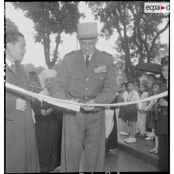 Le général de Linarès coupe un ruban pour l'inauguration de la kermesse organisée au profit des orphelins de l'Asile saint Antoine.