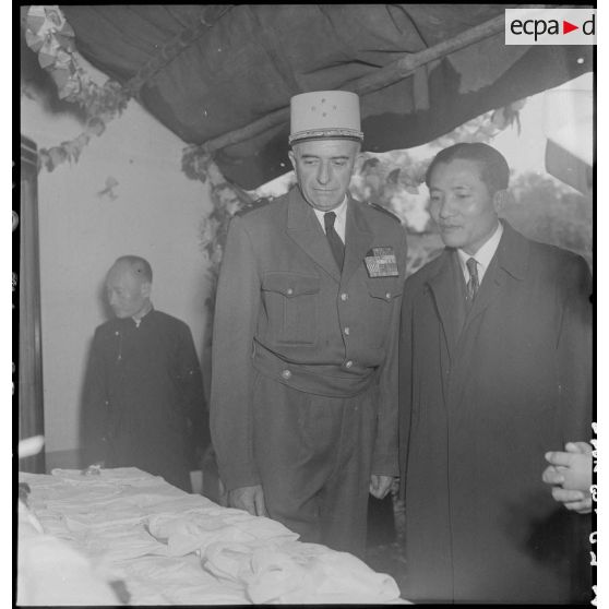 Le général de Linarès et  le représentant du gouverneur du Nord-Vietnam devant un stand d'une kermesse organisée au profit des orphelins de l'asile Saint Antoine au jardin d'enfants d'Hanoï.
