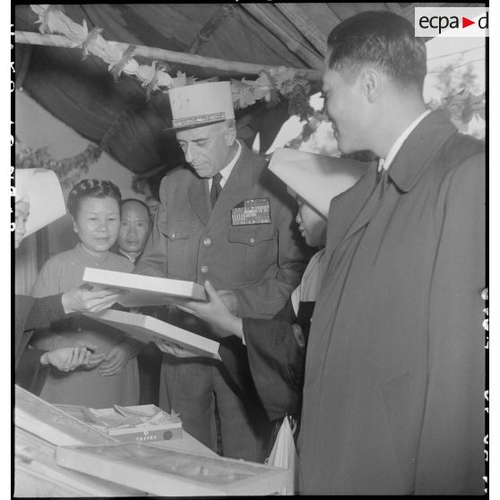Le général de Linarès devant un stand d'une kermesse organisée au profit des orphelins de l'asile Saint Antoine, au jardin d'enfants d'Hanoï.