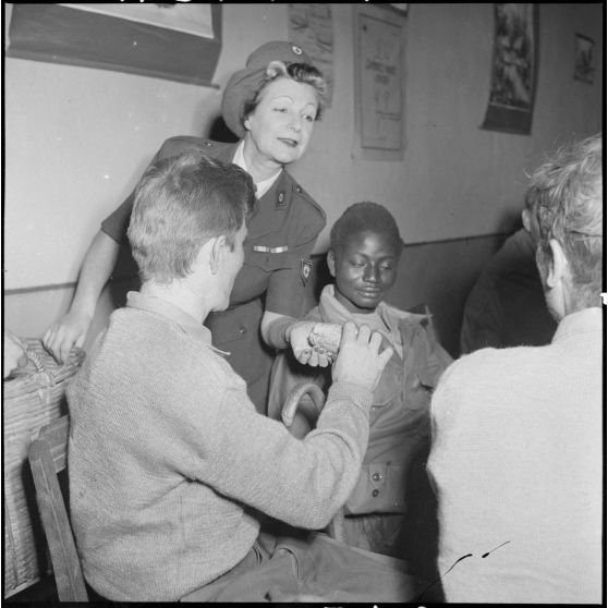 Une femme de la Croix-Rouge donne du pain à des soldats du CEFEO (Corps expéditionnaire français en Extrême-Orient) récemment libérés.