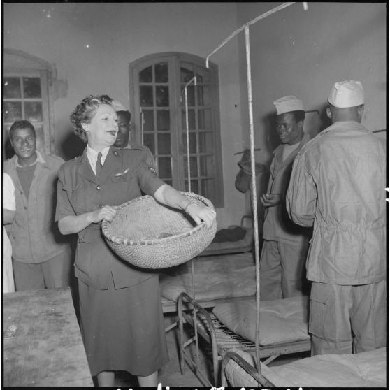 Une femme de la Croix-Rouge donne du pain à des soldats du CEFEO (Corps expéditionnaire français en Extrême-Orient) récemment libérés.