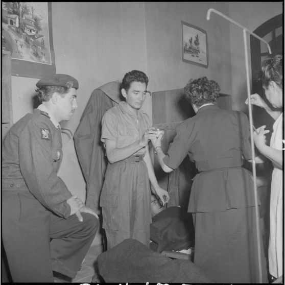 Une femme de la Croix-Rouge donne un verre à un homme du CEFEO (Corps expéditionnaire français en Extrême-Orient) récemment libéré.