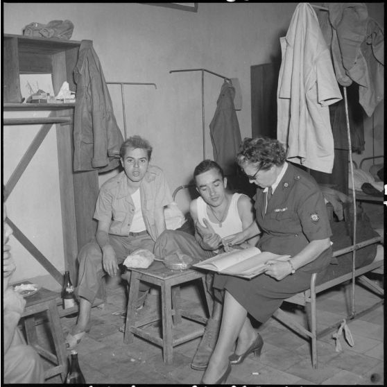 Deux hommes du CEFEO (Corps expéditionnaire français en Extrême-Orient), récemment libérés, en compagnie d'une femme de la Croix-Rouge.