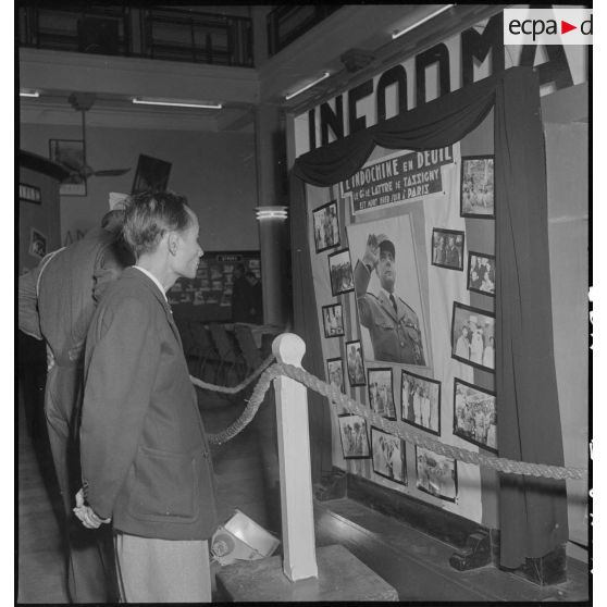 Civil devant un panneau d'information annonçant la mort du maréchal de Lattre de Tassigny dans un hall du Service d'information.