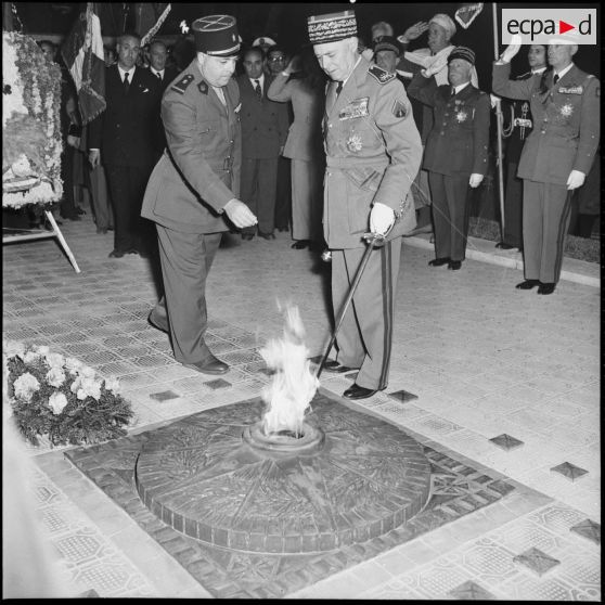 Le maréchal Juin ranime la flamme du soldat inconnu à l'occasion des commémorations de la bataille du Garigliano.