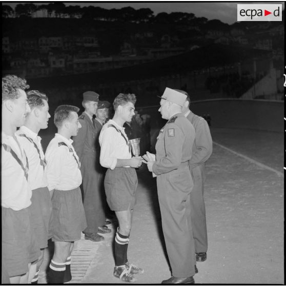 Le général de division remet la coupe à la 10e SIM ; celle-ci pose ensuite pour une photographie de groupe.