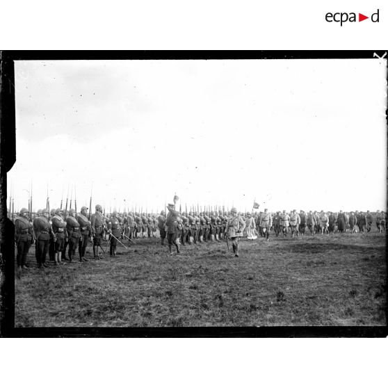 Le roi et la reine des Belges passant en revue la 1re DI de la 1re armée sur le champ d'aviation de Saint-Pol-sur-Mer. [légende d'origine]