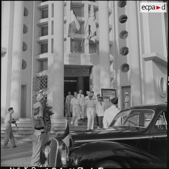 Le général de Linarès et M. Pham Van Binh sortent du bâtiment où a lieu le vernissage de l'exposition "Aimé Seau".