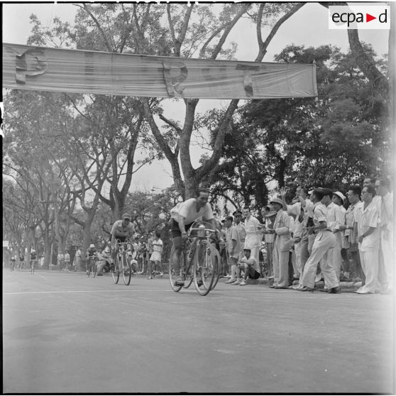 Des coureurs franchisent la ligne d'arrivée de la course cycliste Hanoï-Hadong-Hanoï