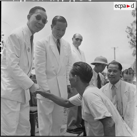 Nguyen Dê serre la main d'un des coureurs cyclistes.