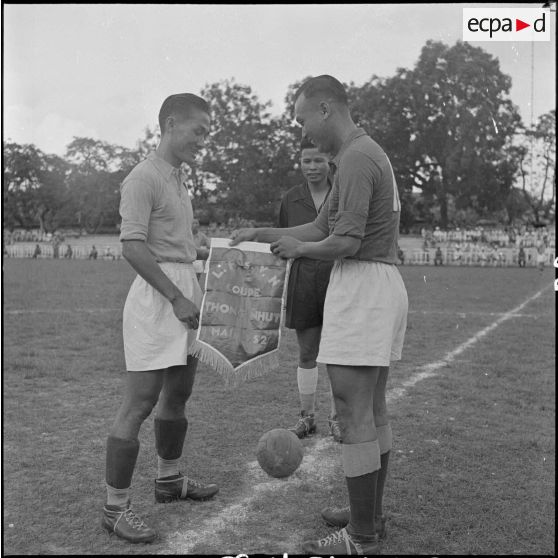 Echange de fanions entre deux footballeurs avant le coup d'envoi de la finale de la coupe de l'Unité.