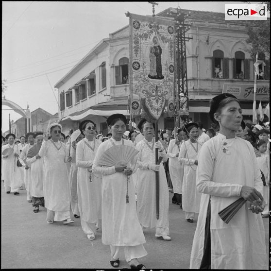 Pendant la fête Dieu, au cours de la procession, des femmes "enfants de Marie" défilent.