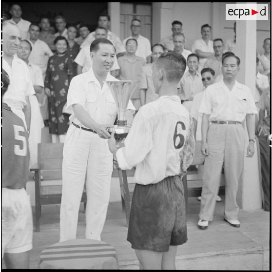 A l'issue du match de football opposant l'équipe de Nam-Hoa à la sélection Nord-Vietnam, M. Pham Van Binh remet au capitaine de l'équipe victorieuse le trophée.