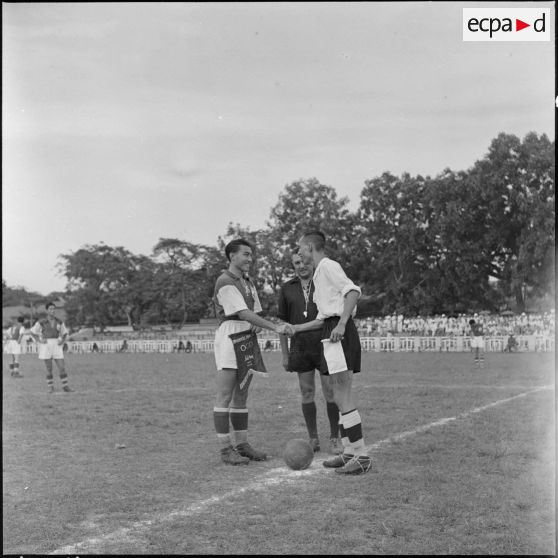 Les capitaines des deux équipes échangent leurs fanions avant le match de football opposant l'équipe de Nam-Hoa à la sélection Nord-Vietnam.