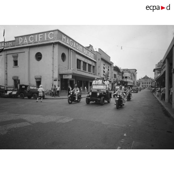 Cortège de véhicules, dans une rue d'Hanoï, à l'occasion de la cérémonie du "Flambeau du sacré".