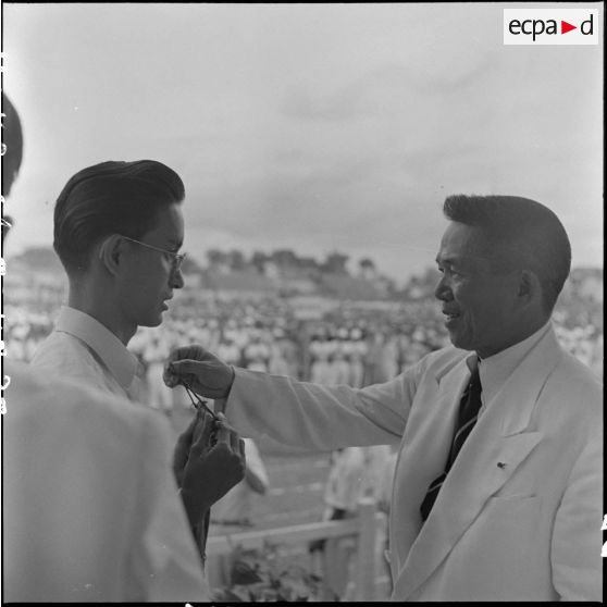 A l'occasion de l'inauguration de la "Semaine de la jeunesse", M. Nguyen Van Tam, président du Conseil des ministres de l'État du Vietnam, remet un  fanion souvenir à un représentant d'un groupement de jeunesse.