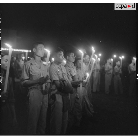 Les militaires franco-vietnamiens porteurs de cierges dans le cortège aux flambeaux lors de la veillée religieuse organisée pour la fête de l'Assomption.