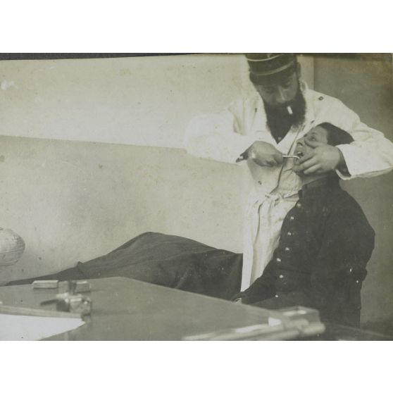 En train d'extirper 1 molaire réfractaire à l'infirmerie du 69e d'Infanterie à Essey les Nancy. Novembre 1913. [légende d'origine]