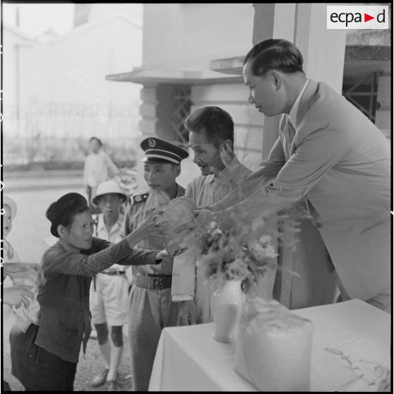 Pham Van Binh, gouverneur du Nord-Vietnam, distribue du riz aux nécessiteux.