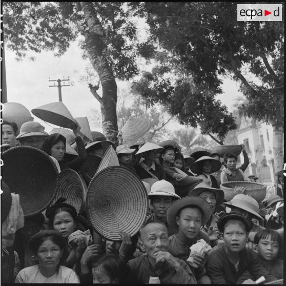 Des nécessiteux attendent l'heure de la distribution de riz.