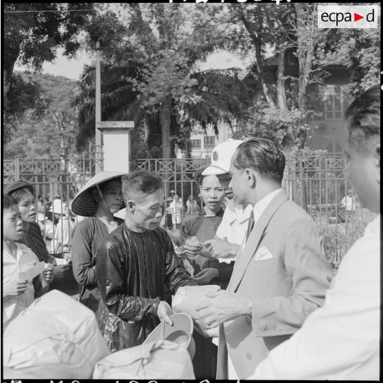 Contre des bons délivrés par l'association des Indiens d'Hanoï, chaque nécessiteux reçoit un paquet de 10 kg de riz.