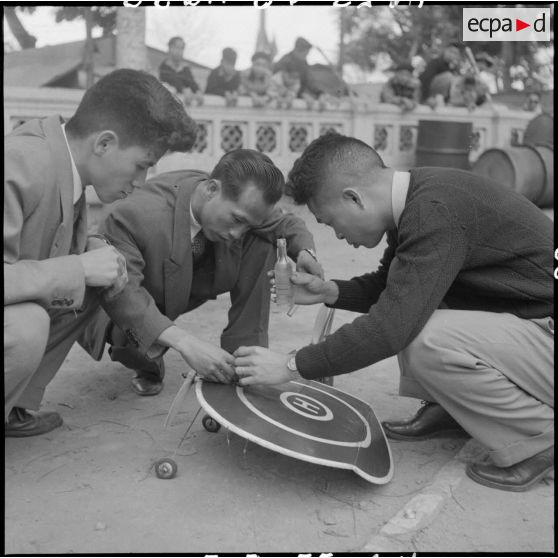 Ces jeunes gens participent à un concours d'avions miniatures qui a lieu à l'occasion de la kermesse organisée au profit des invalides et des blessés de guerre d'Hanoï.