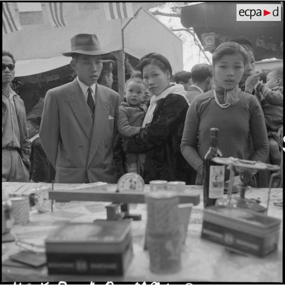 Des personnes devant un stand de la kermesse organisée au profit des invalides et des blessés de guerre d'Hanoï.