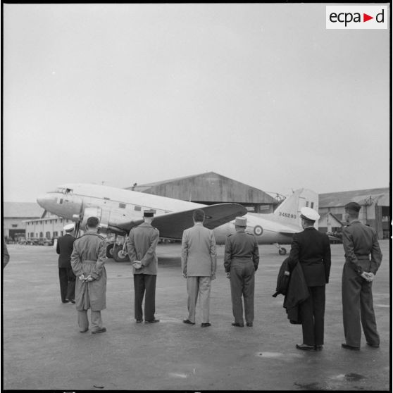 Des personnalités françaises regardent l'avion de M. Paul Reynaud prêt à décoller.