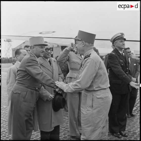 A son arrivée à l'aéroport de Gia Lam, le maréchal Juin serre la main du général de Berchoux.