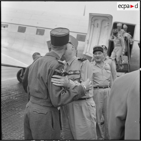 A son arrivée à l'aéroport de Gia Lam, le maréchal Juin embrasse son fils, lieutenant de Légion.