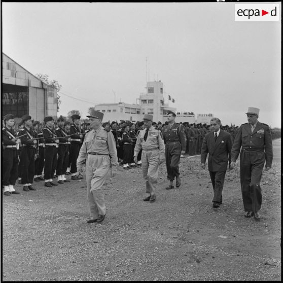 Le maréchal Juin passe les troupes en revue à son arrivée à l'aéroport de Gia Lam.