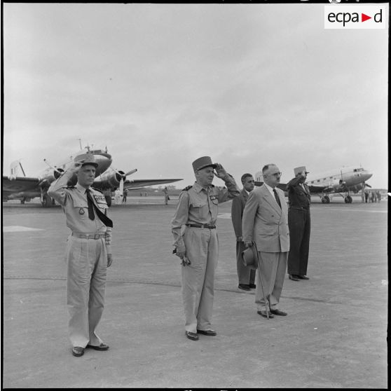 Le général Salan, le maréchal Juin, M. Letourneau, M. Nguyen Huu Tri et le général de Linarès saluent les drapeaux à l'aéroport de Gia Lam.