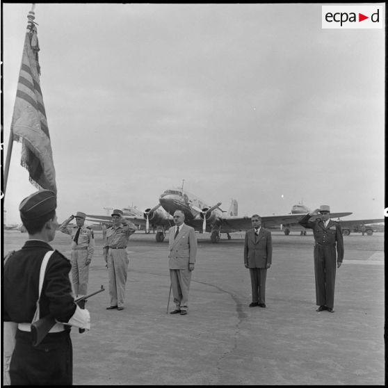 Le général Salan, le maréchal Juin, M. Letourneau, M. Nguyen Huu Tri et le général de Linarès saluent les drapeaux à l'aéroport de Gia Lam.