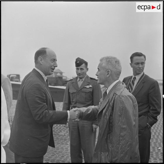 M. Adlai Stevenson serre la main de M. le consul des Etats-Unis à l'aéroport de Gia Lam.