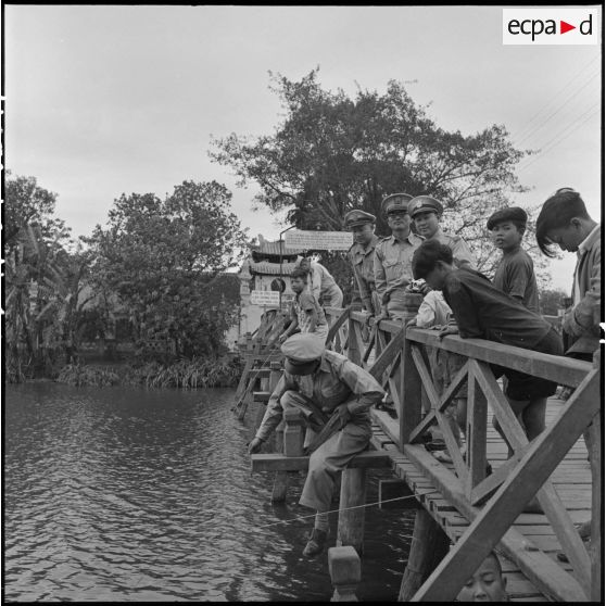 Un officier coréen entouré de deux officiers de l'Armée nationale vietnamienne et d'enfants sur un pont du lac Hoan Kiem.