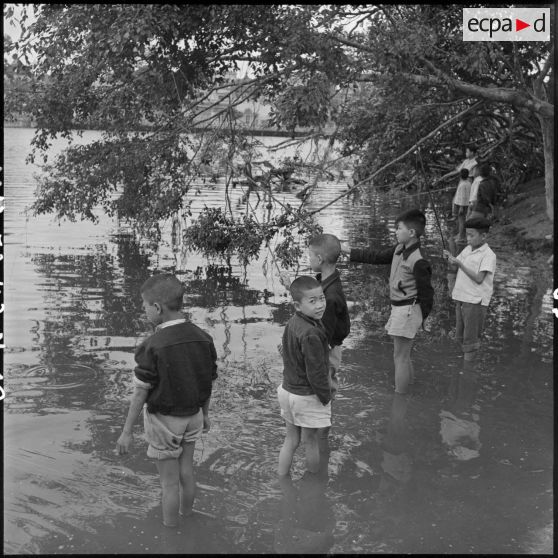 Des enfants pêchent dans le lac Hoan Kiem.